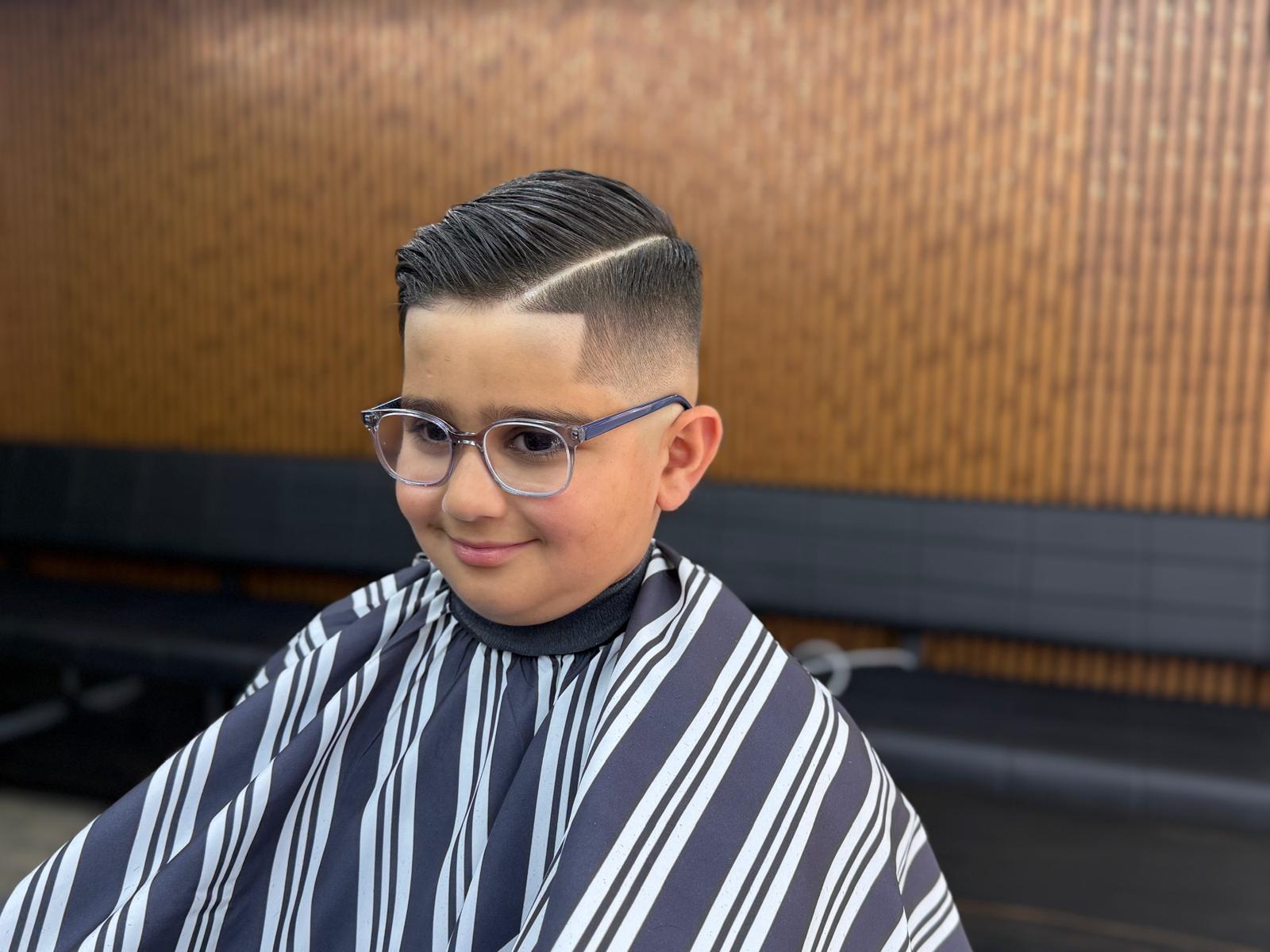 Young client with sharp side part and skin fade design